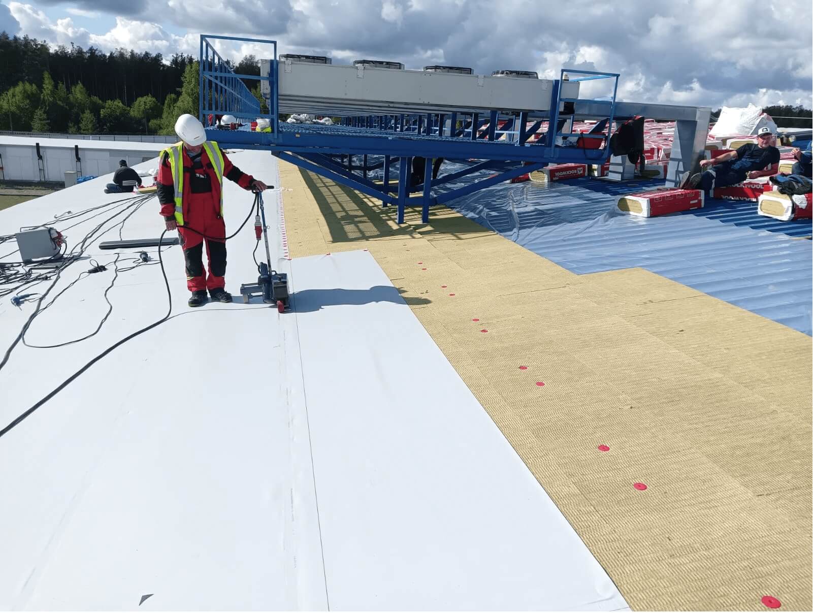 Сварка полотен ПВХ-мембраны автоматическим оборудованием при устройстве плоской кровли на промышленном здании