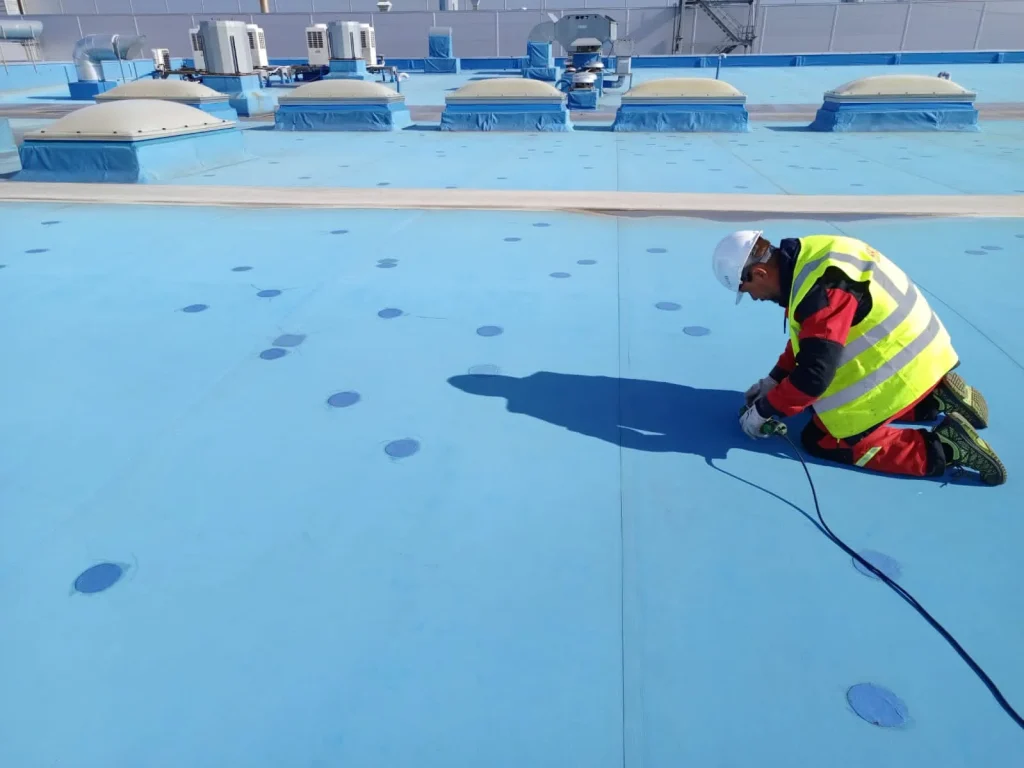 Устранение протечек на плоской кровле синего цвета с помощью сварки ПВХ-мембраны